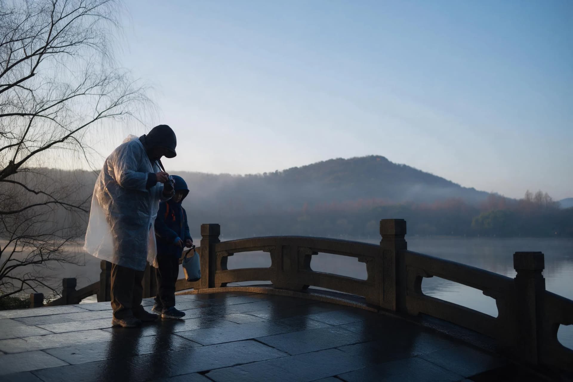 Family photographer adjusting a compact camera beside a misty West Lake stone bridge at dawn in Hangzhou