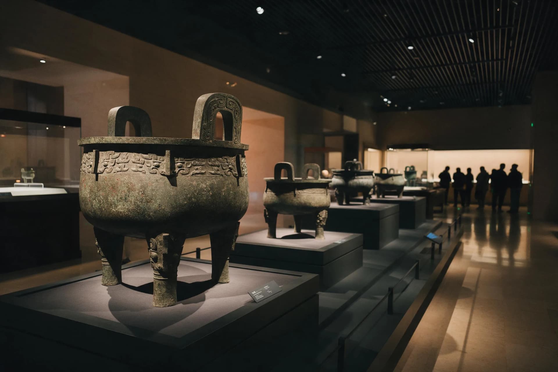 Bronze gallery at the Shanghai Museum East in Pudong, where the Da Ke Ding stands among Western Zhou vessels under low light